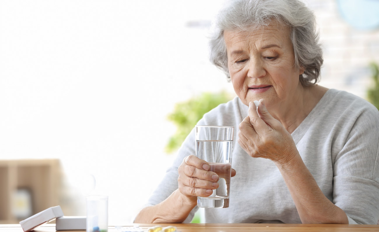 Senior kvinde spiser vitaminpille