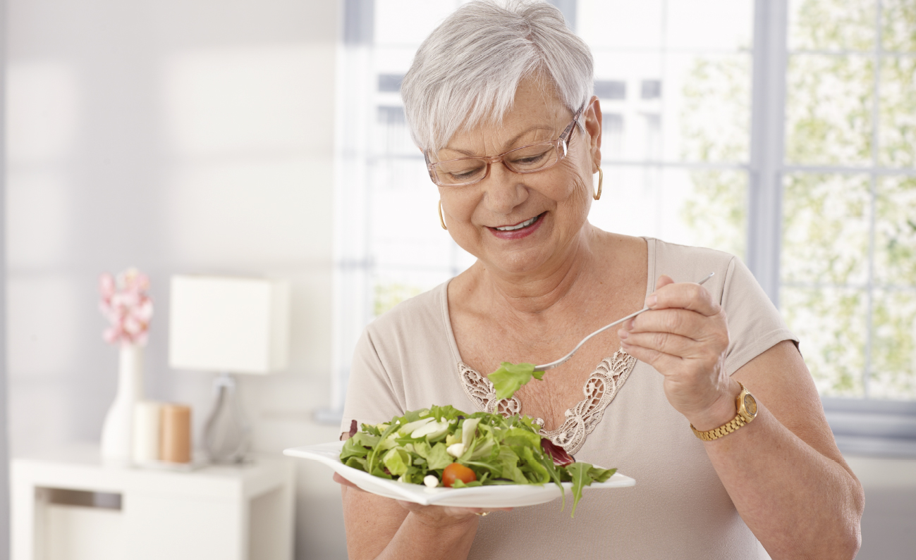 Seniorkvinde spiser salat